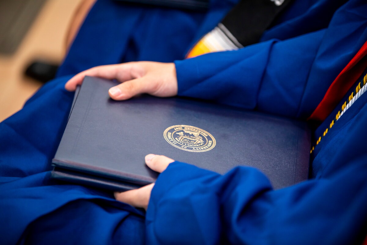Student holds diploma cover