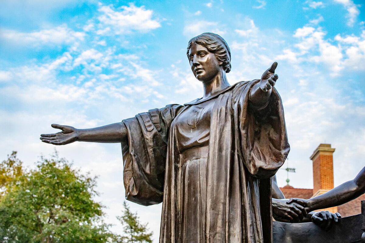 statue of alma with a blue sky and clouds in the background
